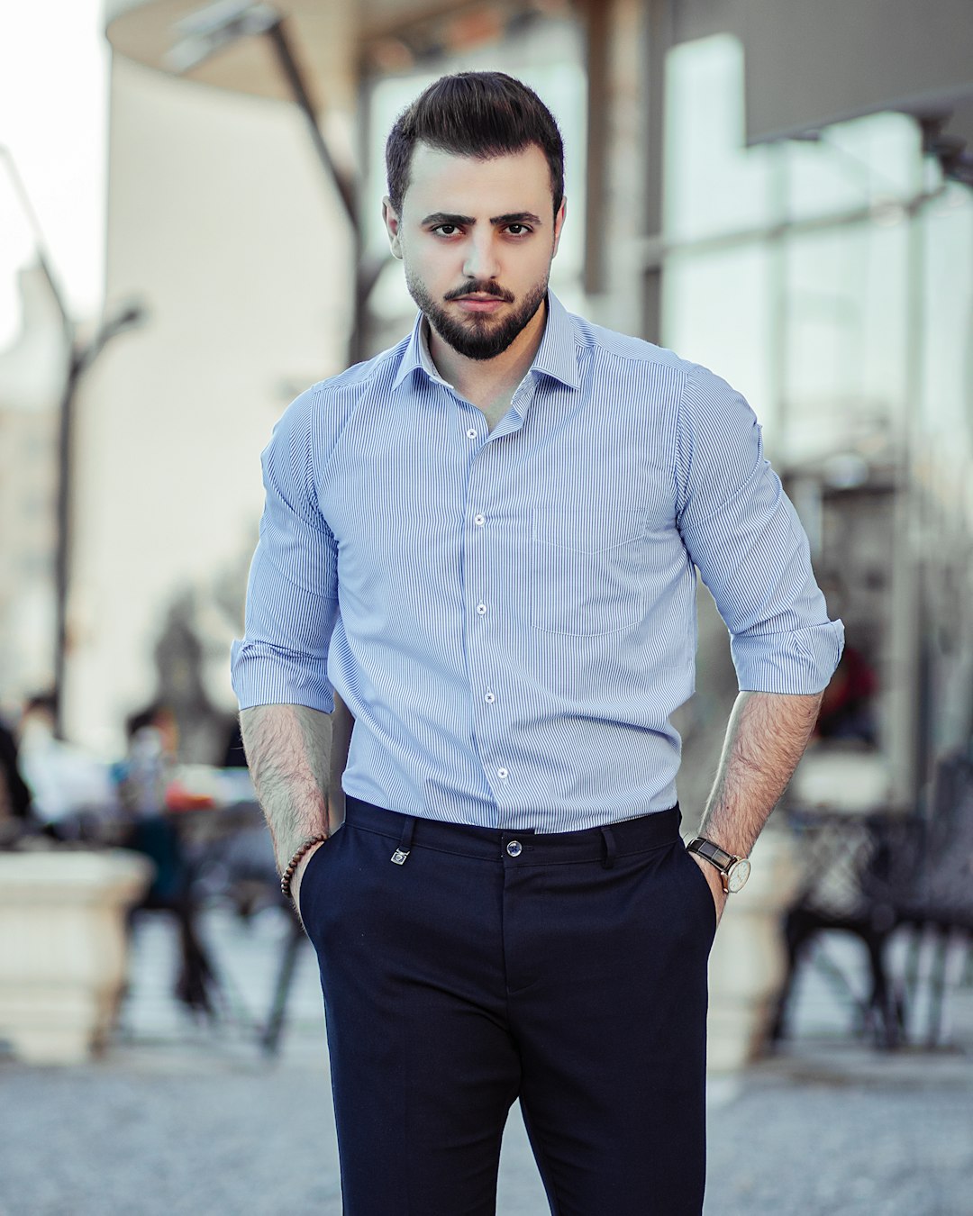 Man wearing a light blue button-up shirt with dark trousers