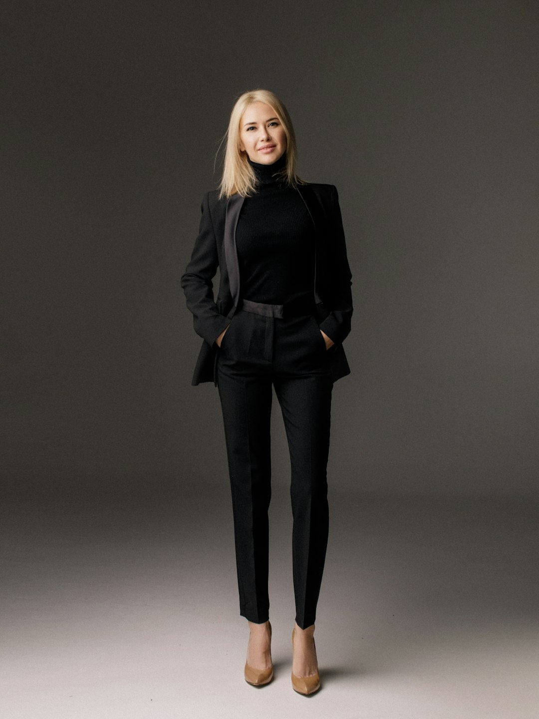 Woman wearing a black jacket and black trousers