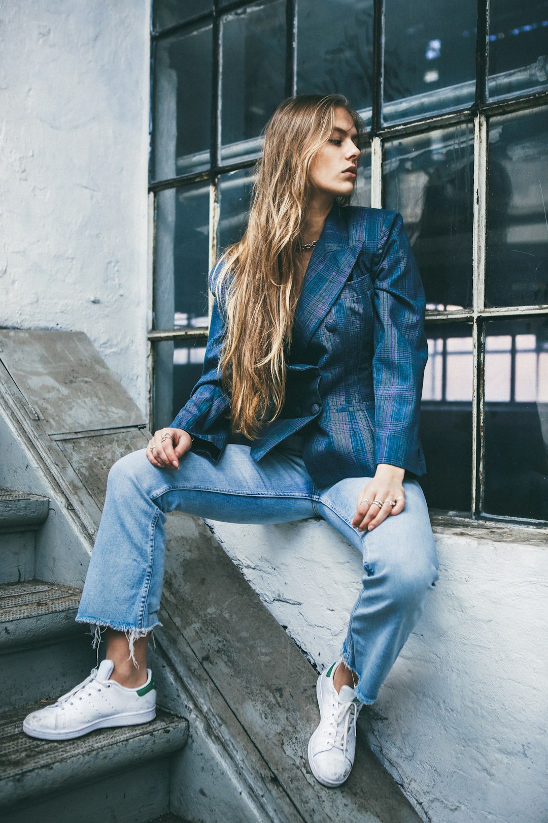 Woman wearing a blazer with jeans and white sneakers